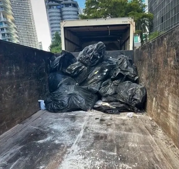Truck bed loaded with bagged commercial junk in downtown Miami high-rise area
