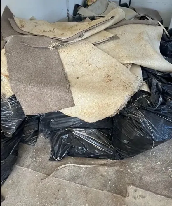 Removed old carpet pieces stacked for junk removal during Miami renovation