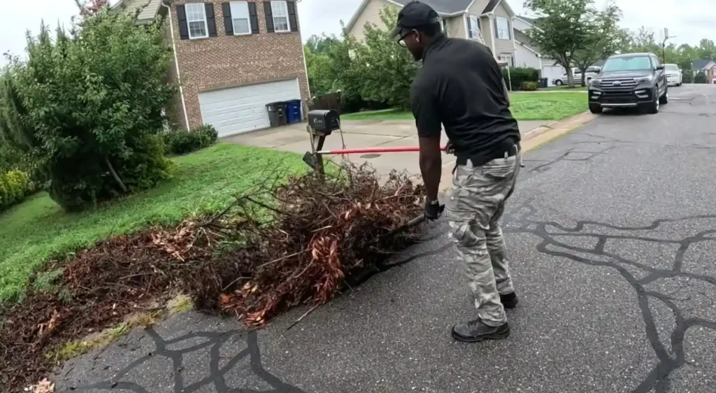 Crew hauling storm-downed tree branches and yard waste from a Pinecrest property
